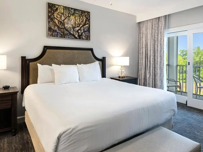 Bedroom with king bed next to balcony doors.
