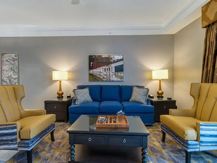 Living room with blue sofa and two yellow armchairs.