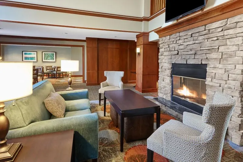 Lobby seating area with sofas and armchairs in front of a stone fireplace.