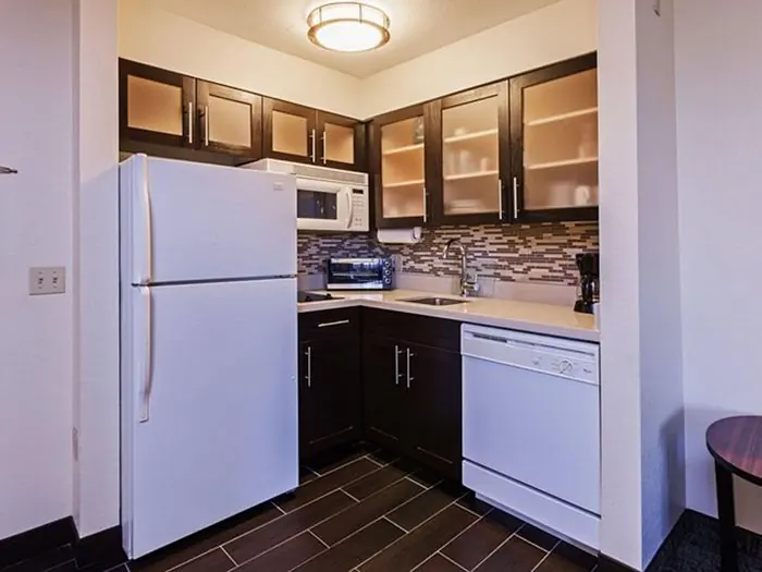 Kitchen with refrigerator, dishwasher, microwave and cabinets.